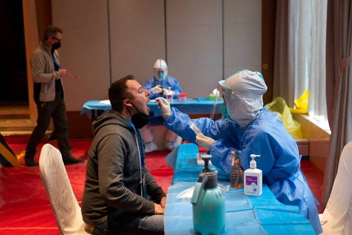 工作人員在冬奧會酒店內對外國記者進行核酸檢測。