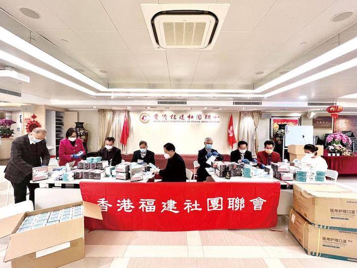 香港福建社團聯會主席吳換炎及義工在包裝口罩和測試包。