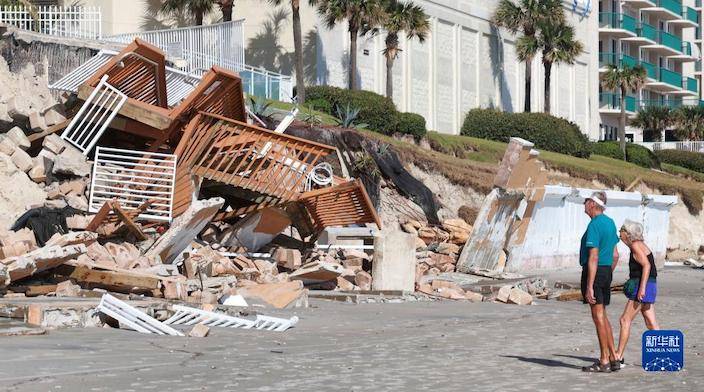10月3日，在美國佛羅里達州代托納比奇海灘，人們查看遭颶風「伊恩」損毀的設施。新華社