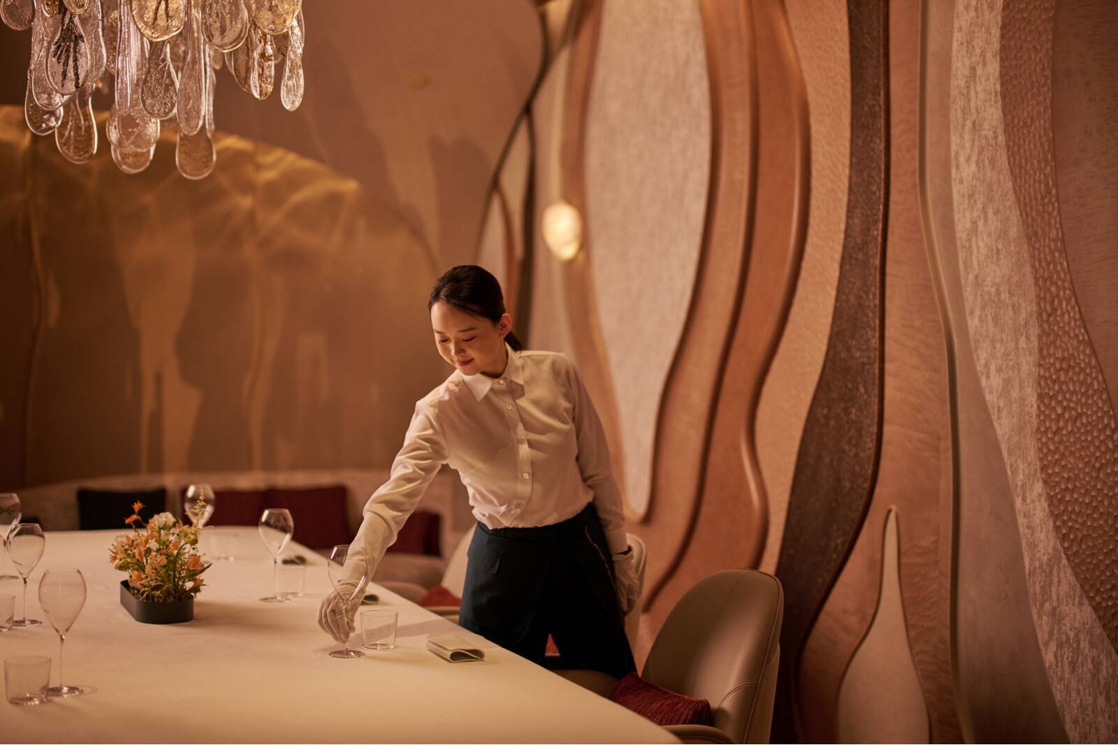 A tumbled-glass chandelier by Lasvit adds a final poetic touch to the private room at Estuary by Vicky Cheng, casting waterlike reflections and natural textures that complete the sensory landscape. 